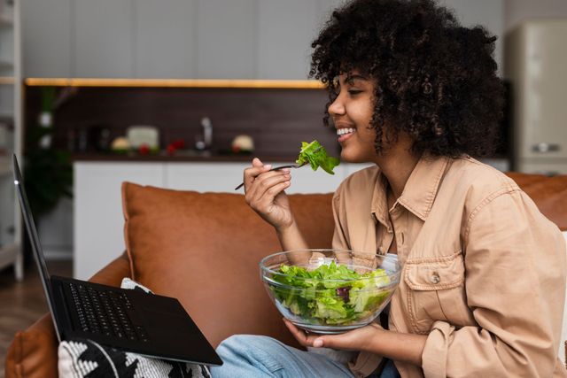 Woman eating a salad while working