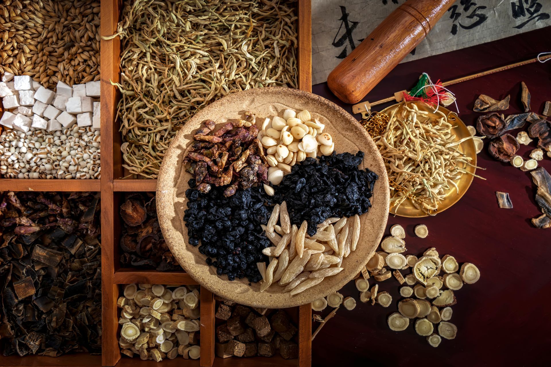 A wooden box filled with a variety of dried Chinese herbs