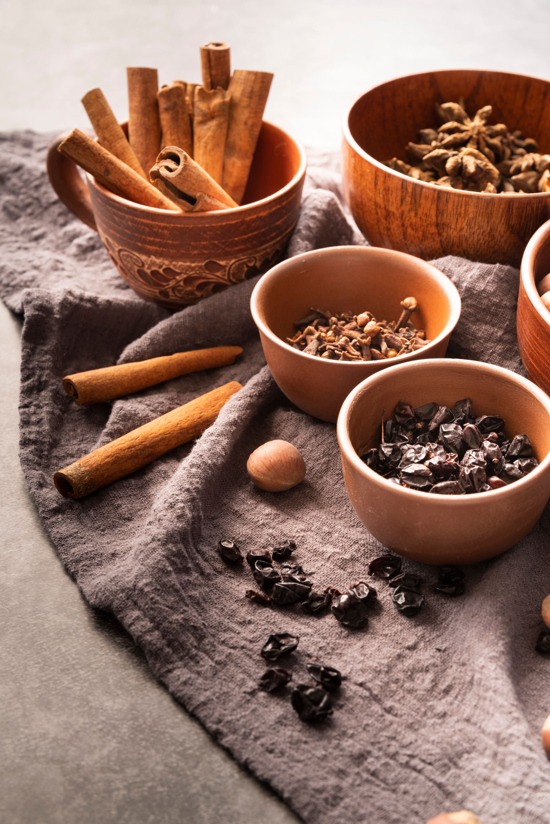 A table with bowls of spices including cinnamon sticks