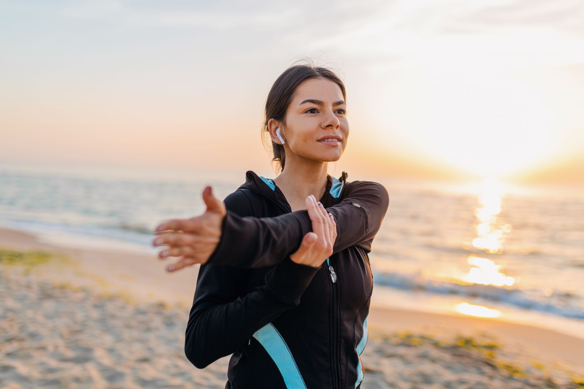 Woman stretching on a beach at sunrise