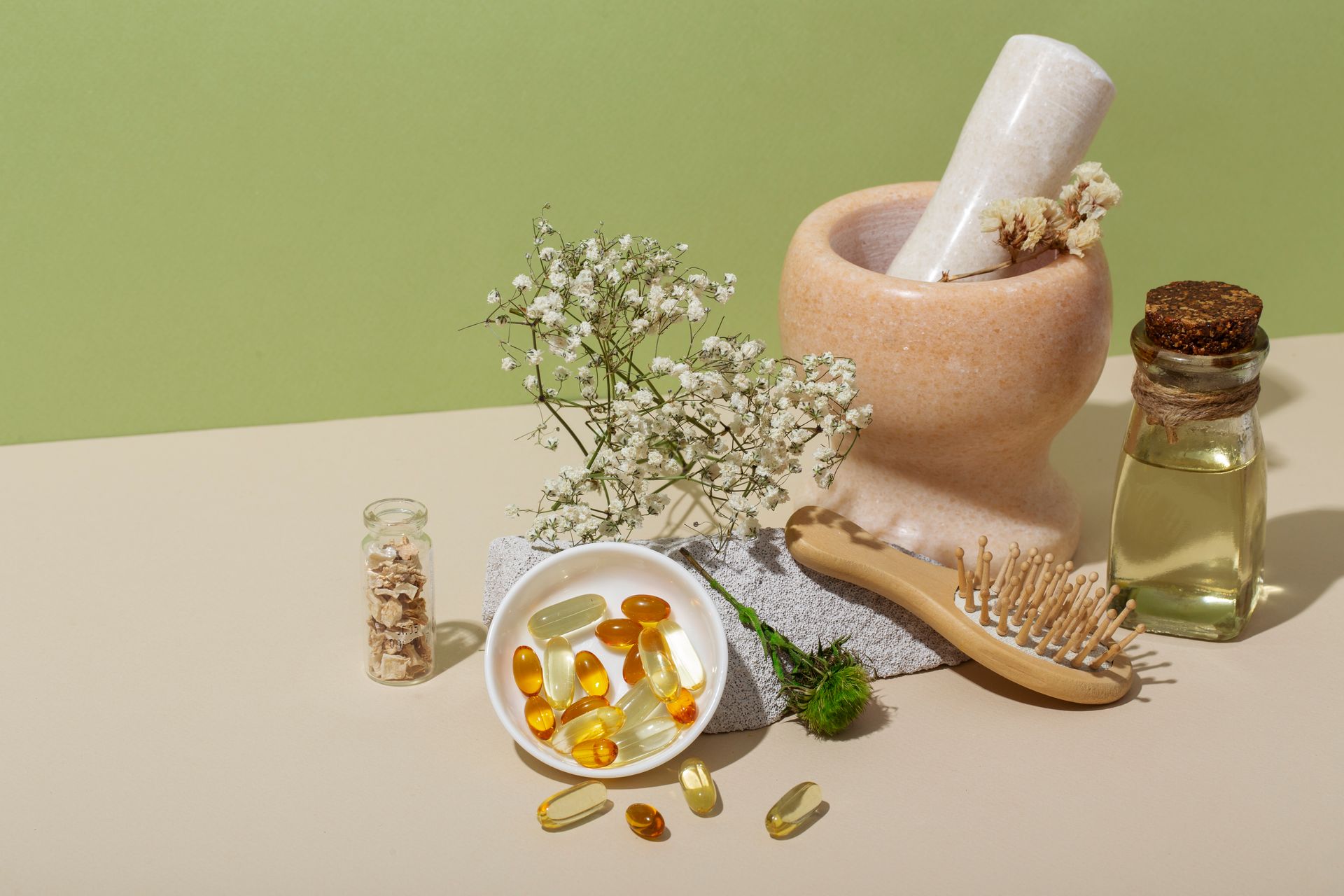 A mortar and pestle next to a bowl of pills and a brush