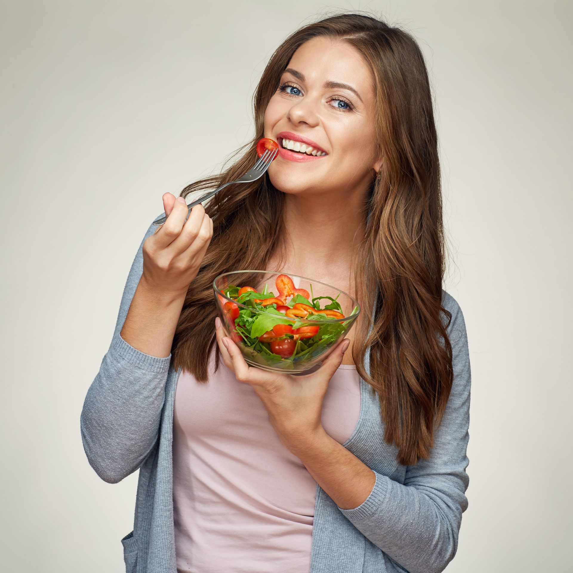 A woman is eating a salad with a fork